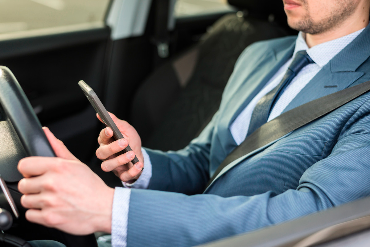 businessman with smartphone car